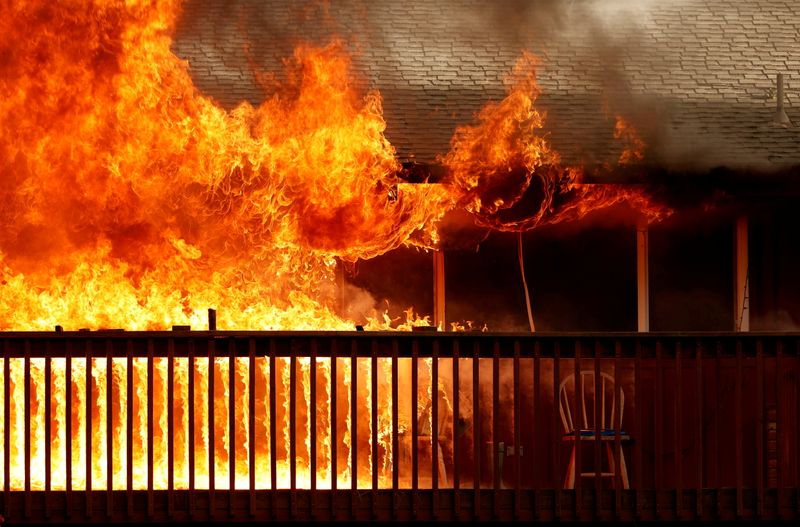 Thousands evacuate fast-moving California wildfire; homes burn
